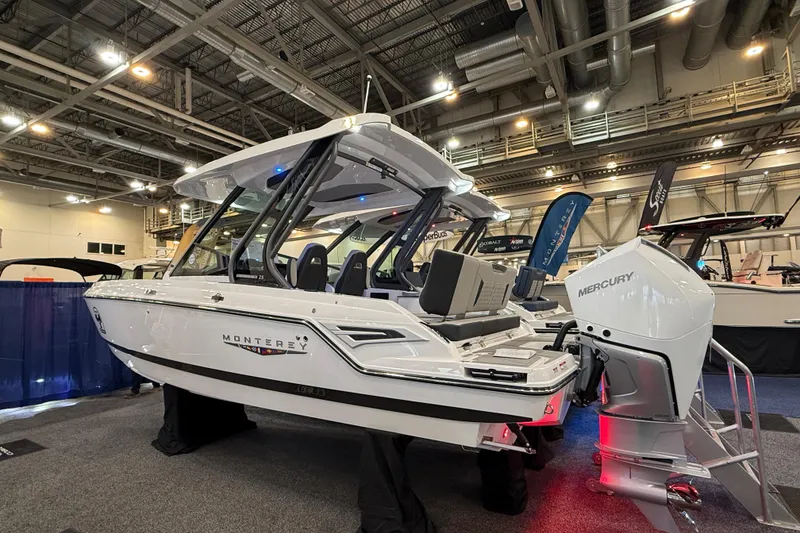 Slide: The Image of 2026 Monterey Elite 25 OB boat displayed indoors with Mercury outboard engine. - 3