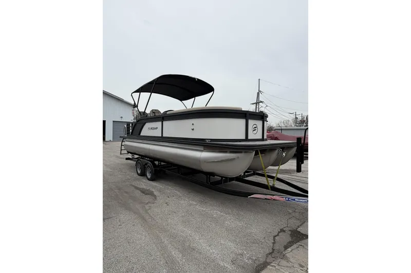 Slide: The Image of 2026 Flagship D22RF Ext. Deck pontoon boat on trailer, parked outdoors. - 6