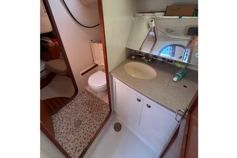 Slide: The Image of Bathroom interior of 1999 Hunter 380 sailboat with sink, toilet, and shower area. - 15