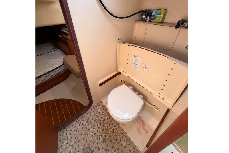 Slide: The Image of Interior of 1999 Hunter 380 yacht bathroom with toilet and adjacent sleeping area. - 17
