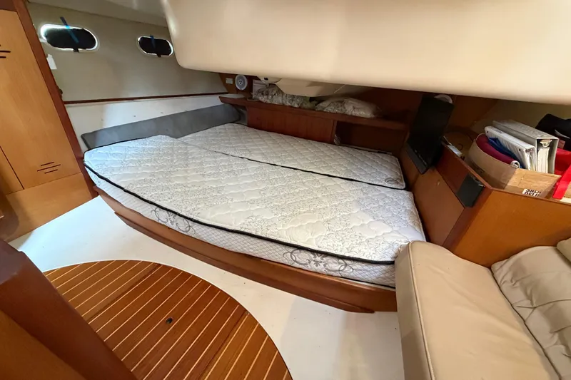 Slide: The Image of Interior cabin of a 1999 Hunter 380 sailboat with a double bed and wooden furnishings. - 18