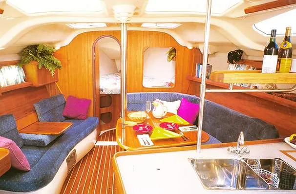 Slide: The Image of Interior of a 1999 Hunter 380 yacht, featuring cozy seating. - 27
