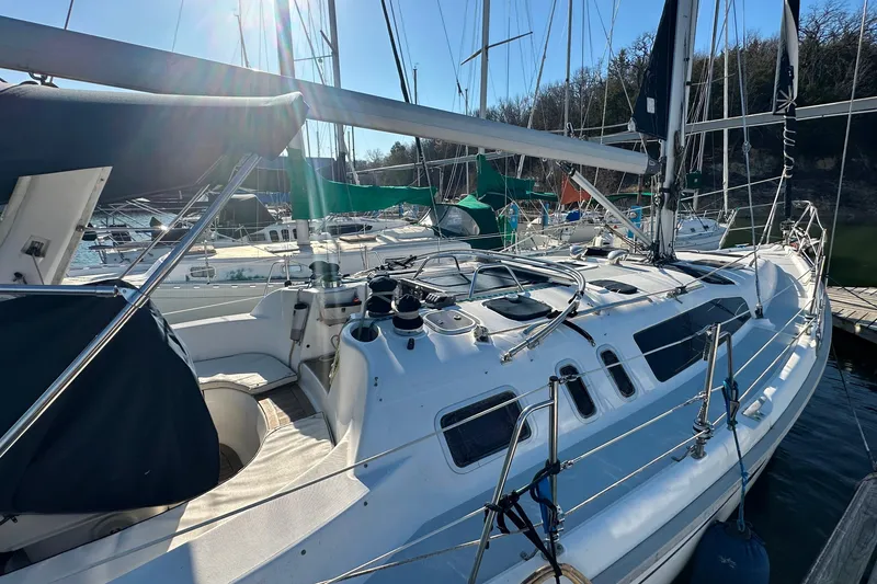 Slide: The Image of 1999 Hunter 380 sailboat docked at marina, surrounded by other boats. - 7