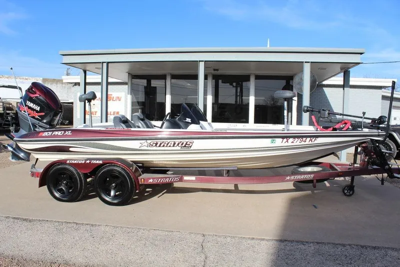 Slide: The Image of 2005 Stratos 201 Pro XL boat with Yamaha engine on trailer, parked outside a building. - 12