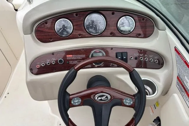 Slide: The Image of 2007 Sea Ray 240 Sundeck dashboard with wood accents and steering wheel. - 11