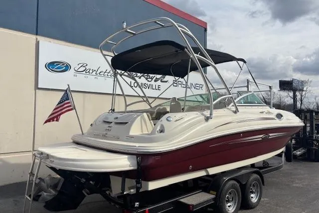 Slide: The Image of 2007 Sea Ray 240 Sundeck boat on trailer, American flag, dealership background. - 6