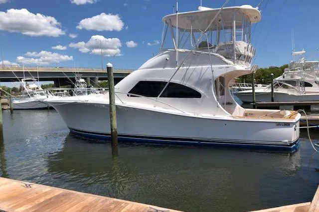 The Image of 2005 Luhrs 41 Convertible yacht docked in marina under blue sky. - 0