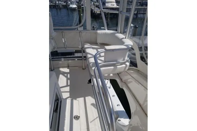 Slide: The Image of 2005 Luhrs 41 Convertible yacht interior with white seating and railing, docked at marina. - 30