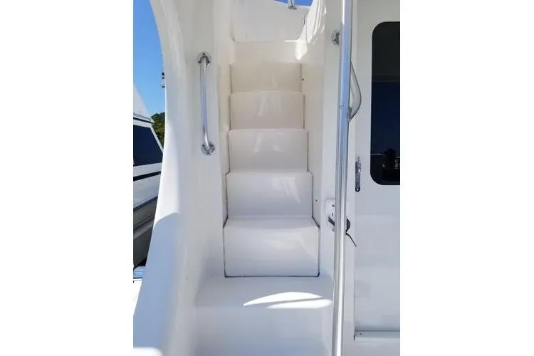 Slide: The Image of Staircase on 2005 Luhrs 41 Convertible yacht, featuring sleek white design and metal handrails. - 32