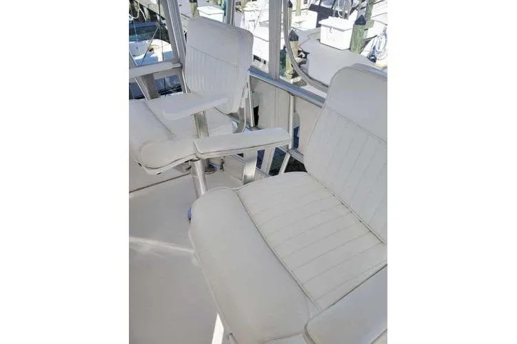 Slide: The Image of 2005 Luhrs 41 Convertible boat with white captain chairs on the deck. - 34