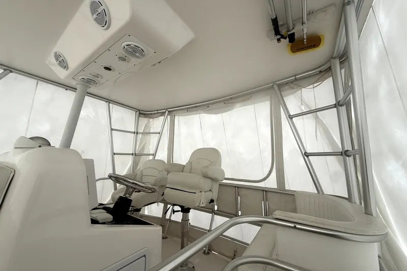 Slide: The Image of 2004 Luhrs 41 Convertible boat helm with white seating and enclosed cockpit. - 42