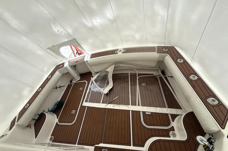 Slide: The Image of 2004 Luhrs 41 Convertible boat interior with wood flooring and white seating. - 47