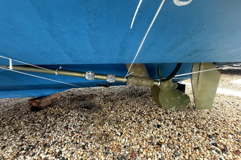 Slide: The Image of 2004 Luhrs 41 Convertible boat propeller and shaft on gravel surface. - 48