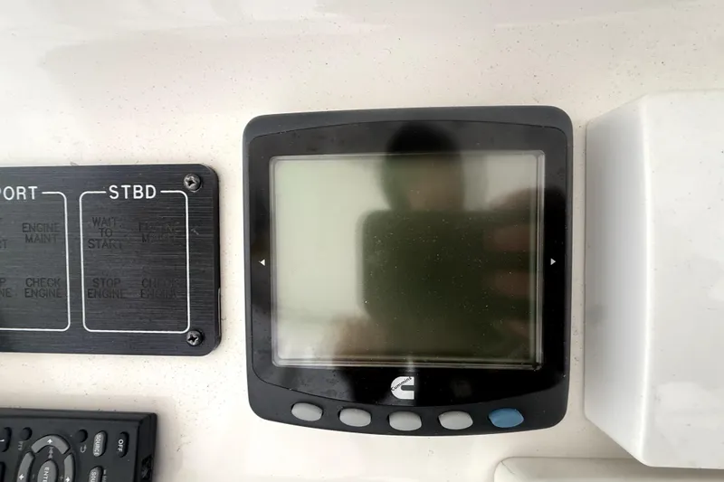 Slide: The Image of Control panel on a 2004 Luhrs 41 Convertible boat, featuring a display and labeled buttons. - 52