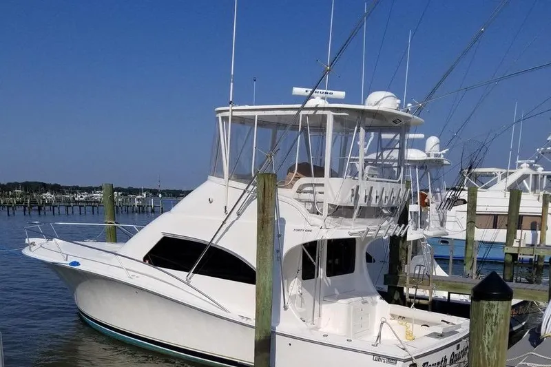 Slide: The Image of 2005 Luhrs 41 Convertible yacht docked at marina under clear blue sky. - 6
