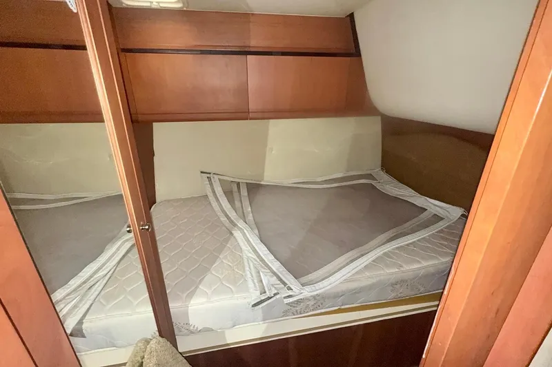 Slide: The Image of 2004 Luhrs 41 Convertible cabin interior with bed and wooden cabinetry. - 64