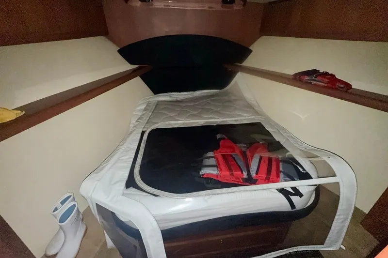 Slide: The Image of 2004 Luhrs 41 Convertible cabin with bed, life jackets, and boots. - 65