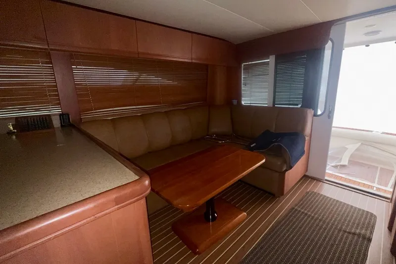 Slide: The Image of 2004 Luhrs 41 Convertible yacht interior with leather seating and wooden table. - 67