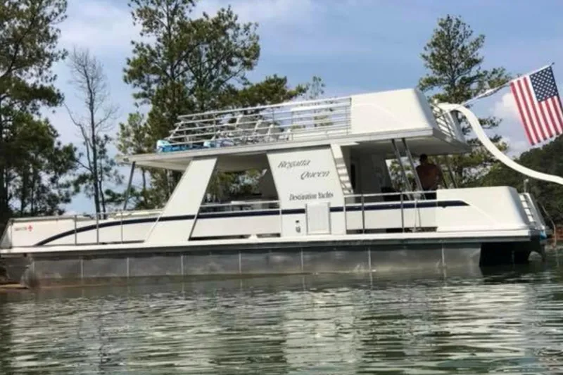 The Image of 2008 Destination Yachts 45X14 houseboat on a serene lake with American flag. - 0