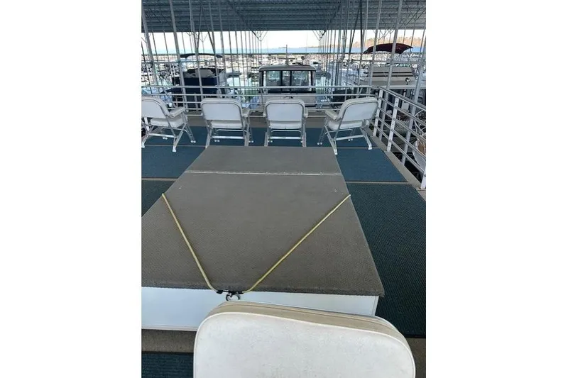 Slide: The Image of 2008 Destination Yachts 45X14 yacht deck with seating and railing, docked by the water. - 15