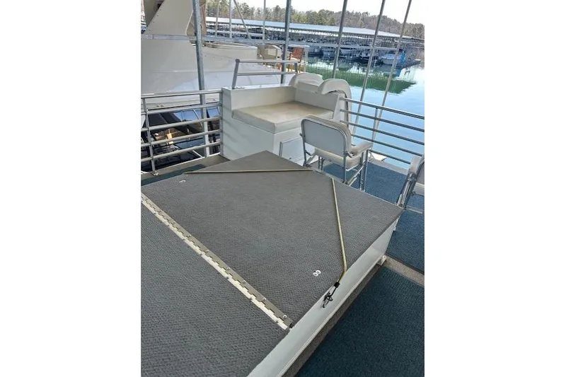 Slide: The Image of 2008 Destination Yachts 45X14 houseboat docked, rear view with two people on deck. - 17