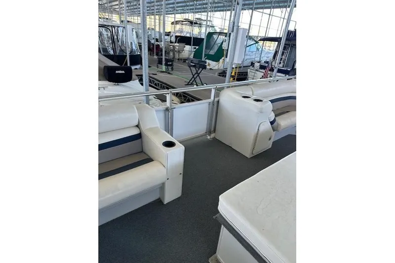 Slide: The Image of 2008 Destination Yachts 45X14 interior with white seating and cup holders in a marina. - 2