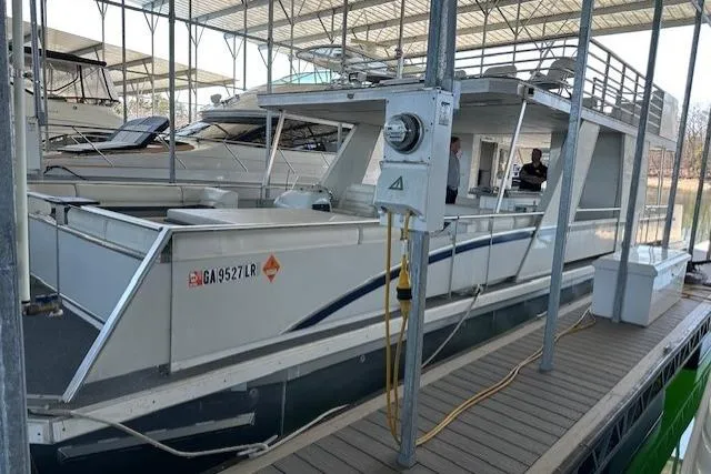 Slide: The Image of 2008 Destination Yachts 45X14 houseboat on a serene lake with lush trees. - 21