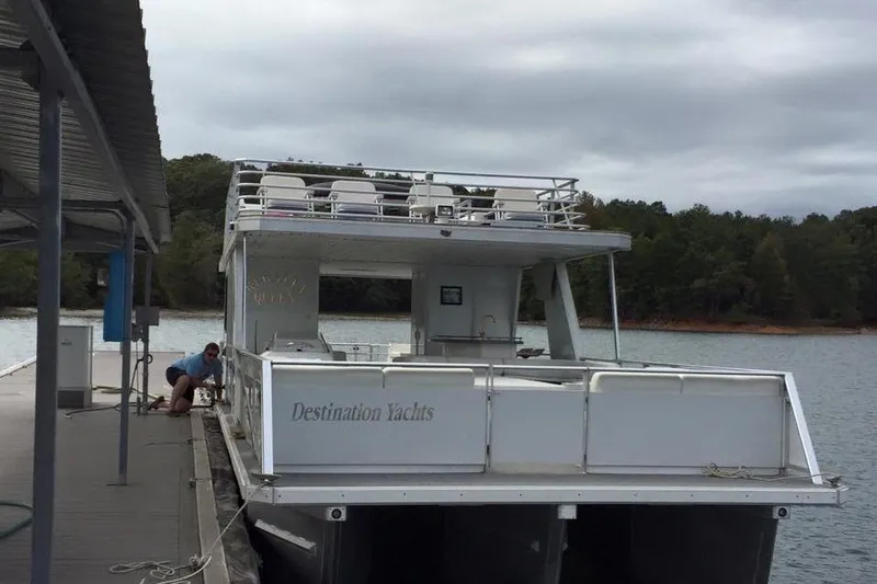 Slide: The Image of 2008 Destination Yachts 45X14 houseboat docked on a lake with trees in the background. - 25