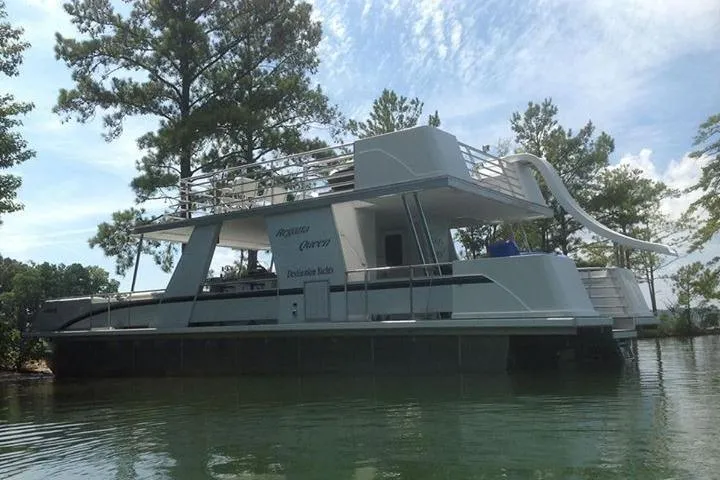 Slide: The Image of 2008 Destination Yachts 45X14 houseboat with slide, docked on a serene lake. - 28