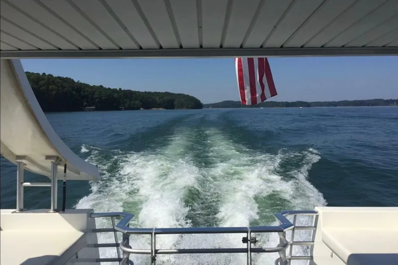 Slide: The Image of 2008 Destination Yachts 45X14 cruising on a lake with American flag and wake view. - 35