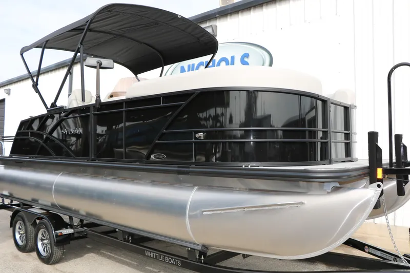 Slide: The Image of 2025 Sylvan MIRAGE 822 CLZ DH pontoon boat on trailer, black exterior, under canopy. - 3