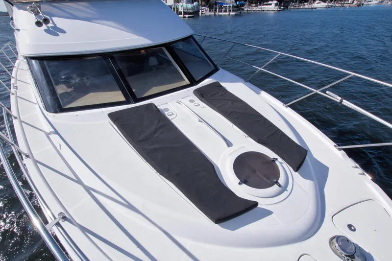 Slide: The Image of 2007 Meridian 459 Motoryacht deck with sun pads, docked on calm water. - 23