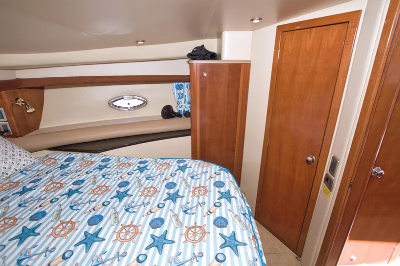 Slide: The Image of 2007 Meridian 459 Motoryacht bedroom with nautical-themed bedding and wooden cabinetry. - 52