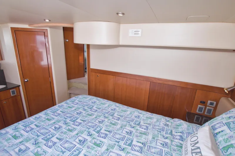 Slide: The Image of Luxurious 2007 Meridian 459 Motoryacht bedroom with wood accents and nautical-themed bedding. - 66