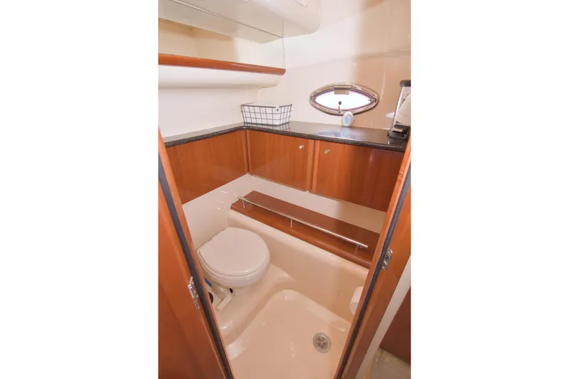 Slide: The Image of 2007 Meridian 459 Motoryacht bathroom with wooden cabinets and porthole window. - 71