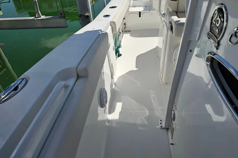 Slide: The Image of 2021 Sea Hunt Gamefish 27 boat interior with forward seating, docked by the water. - 27