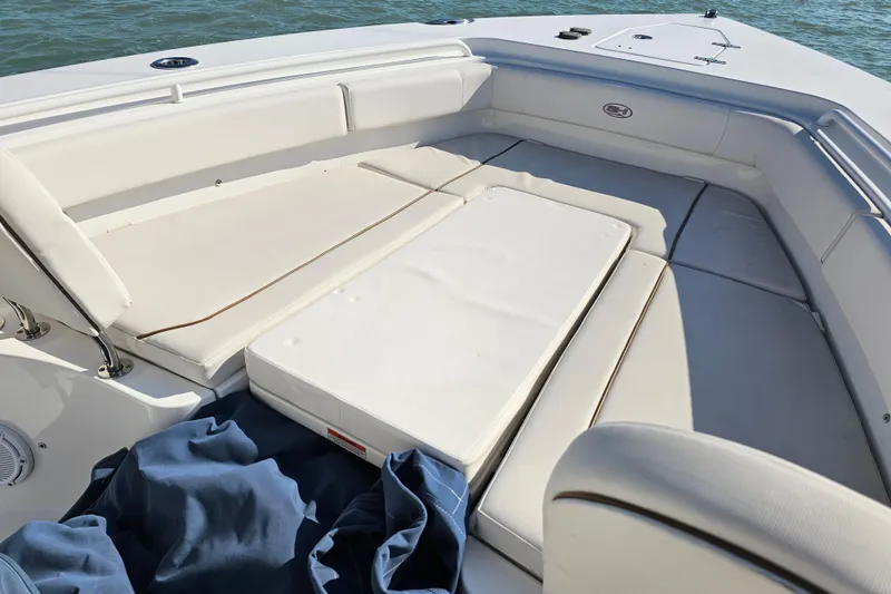 Slide: The Image of 2021 Sea Hunt Gamefish 27 Forward Seating, spacious white cushioned area, on calm water. - 42