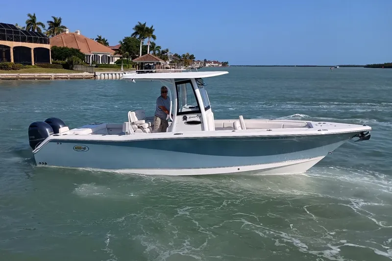 Slide: The Image of 2021 Sea Hunt Gamefish 27 boat cruising in sunny coastal waters. - 6