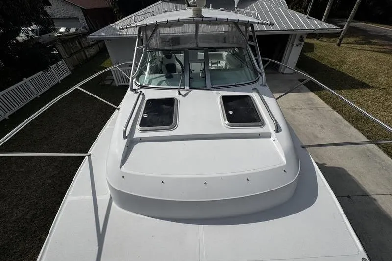 Slide: The Image of 2001 Glacier Bay 260 Canyon Runner boat, top view, docked near a house. - 10