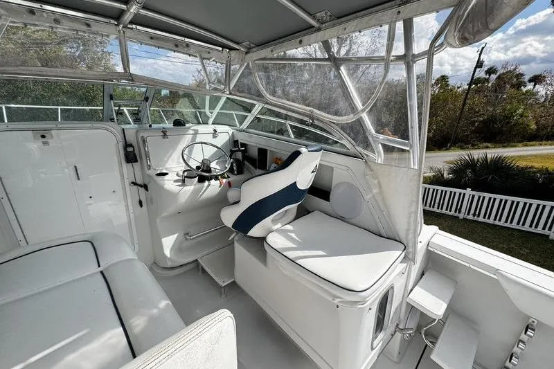 Slide: The Image of Interior of a 2001 Glacier Bay 260 Canyon Runner boat, featuring helm and seating area. - 15