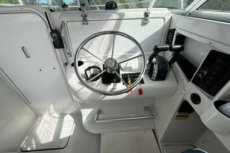 Slide: The Image of 2001 Glacier Bay 260 Canyon Runner boat helm with steering wheel and controls. - 17