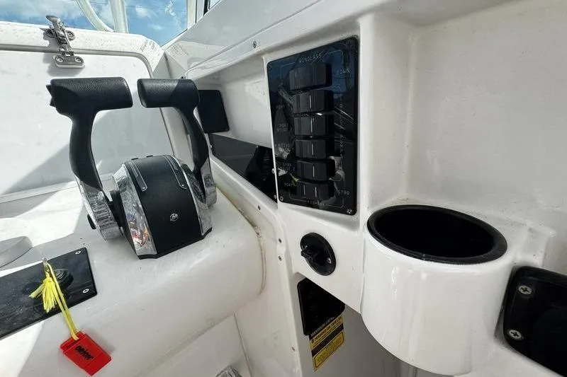 Slide: The Image of Control panel of a 2001 Glacier Bay 260 Canyon Runner boat, featuring throttle levers and switches. - 21