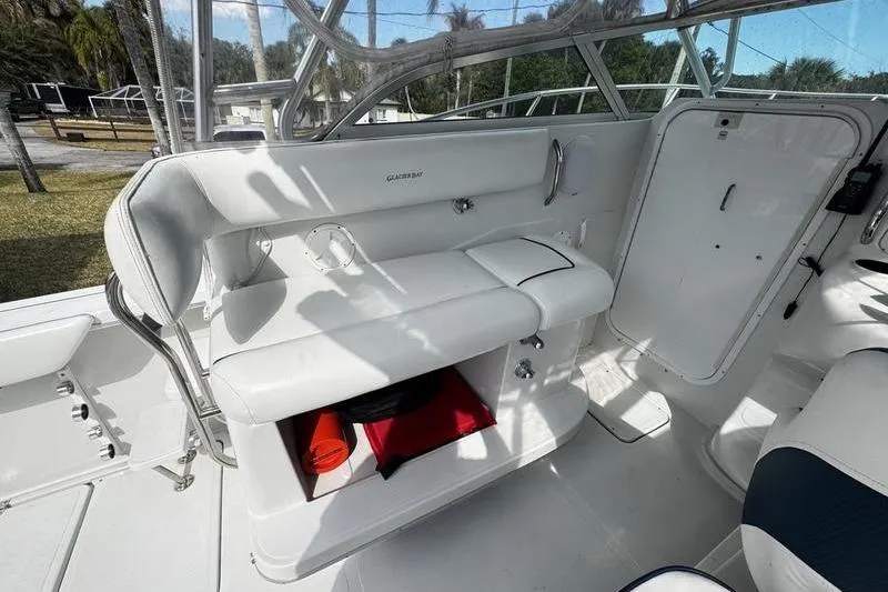 Slide: The Image of 2001 Glacier Bay 260 Canyon Runner interior with white seating and storage compartment. - 23