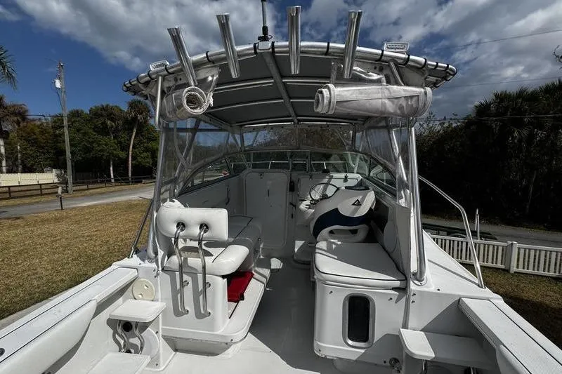 Slide: The Image of 2001 Glacier Bay 260 Canyon Runner boat interior with seating and canopy under cloudy sky. - 25