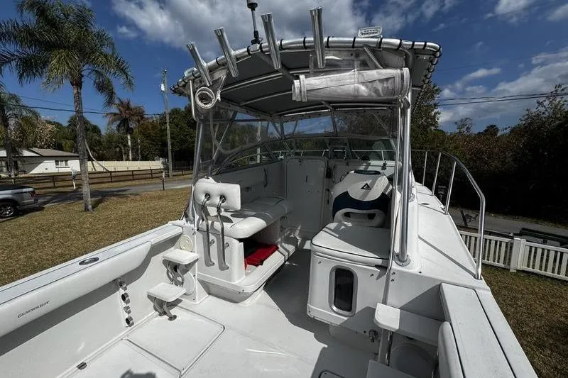 Slide: The Image of 2001 Glacier Bay 260 Canyon Runner boat with seating and canopy, parked outdoors. - 34
