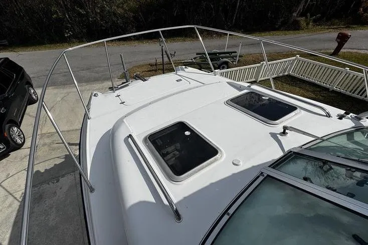 Slide: The Image of 2001 Glacier Bay 260 Canyon Runner boat deck with hatches and railing, parked on driveway. - 35