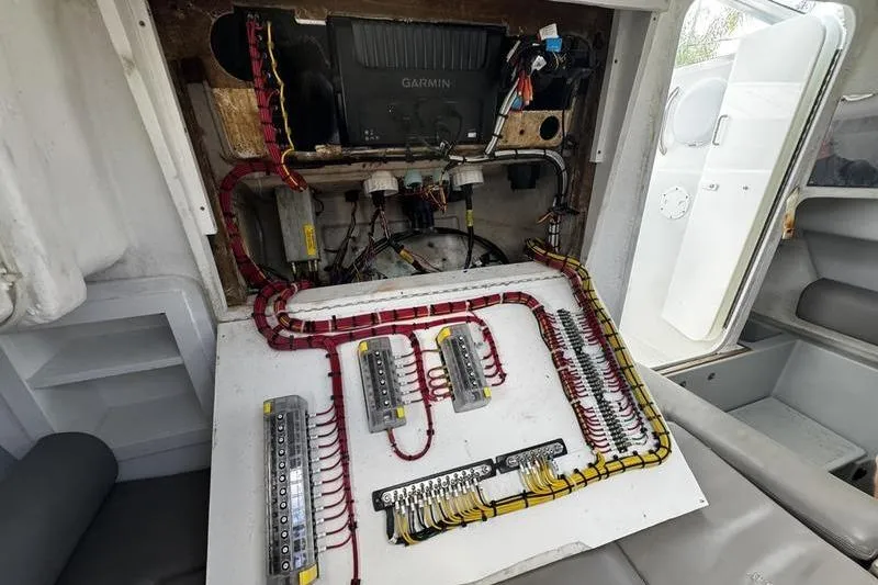 Slide: The Image of Electrical panel inside a 2001 Glacier Bay 260 Canyon Runner boat, featuring organized wiring and Garmin equipment. - 44