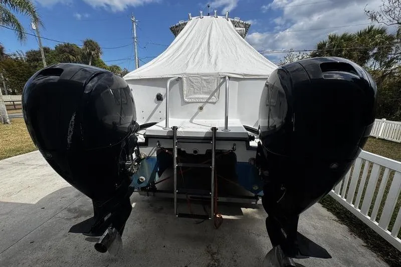 Slide: The Image of 2001 Glacier Bay 260 Canyon Runner with twin outboard motors, covered and parked outdoors. - 5