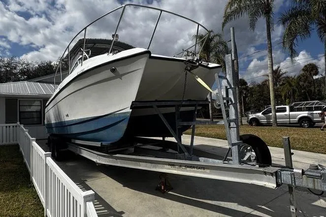 Slide: The Image of 2001 Glacier Bay 260 Canyon Runner boat on trailer, parked in driveway with palm trees. - 7