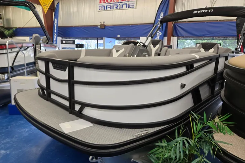 Slide: The Image of 2026 Evotti 521CS pontoon boat displayed indoors at a marine showroom. - 2